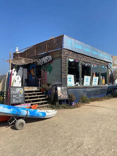 Fachada del Club Marmota en Playa La Boca, Concón, con tablas de surf y kayaks
